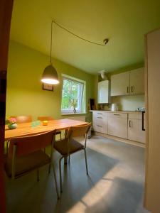 eine Küche mit einem Holztisch und Stühlen in der Unterkunft Fewo am Theater mit Terrasse und Stellplatz in Stralsund