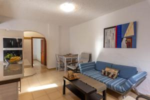 a living room with a blue couch and a table at The old Phone Center house in Ierápetra