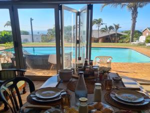 a dining table with a view of a swimming pool at Milk and Honey Guesthouse in Durban