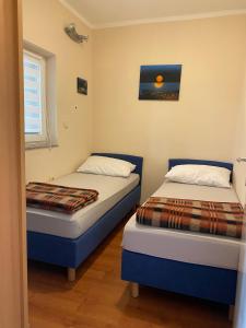 2 Betten in einem kleinen Zimmer mit Fenster in der Unterkunft Apartment Kri-Mar in Selce
