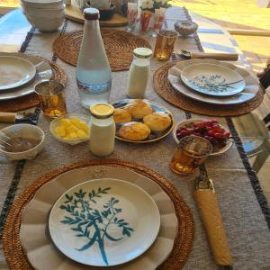 una mesa con platos de comida y bebidas. en Milk and Honey Guesthouse, en Durban