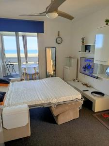 um quarto com uma cama grande e uma mesa com um relógio em Studio Vue Mer 100 m de la plage em Port Leucate
