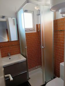 uma pequena casa de banho com um chuveiro e um lavatório. em Studio Vue Mer 100 m de la plage em Port Leucate