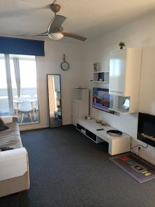 uma sala de estar com um sofá e uma televisão em Studio Vue Mer 100 m de la plage em Port Leucate