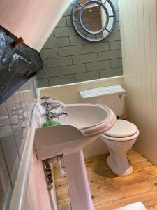 a bathroom with a sink and a toilet at Bakers Cottage Ludham - Norfolk Broads in Ludham