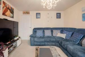 a living room with a blue couch and a television at Hemsworth Homestay with Double Bedroom and Private Bathroom in Hemsworth