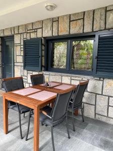 a wooden table and chairs in front of a brick wall at Apartment Kri-Mar in Selce