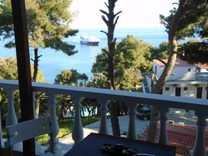 a balcony with a view of the ocean and a cruise ship at Machi Rooms in Patitiri