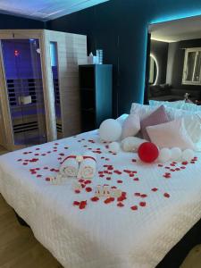 - un lit avec des pétales de rose rouge dans l'établissement Suite & Spa Jacuzzi, sauna, lit king size,Netflix, à Montigny-le-Bretonneux