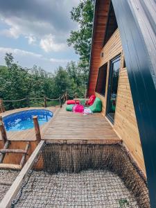 a wooden deck with a swimming pool next to a house at Loca Sapanca Bungalov in Sapanca