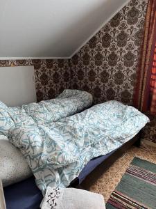 a bed with a comforter on it in a bedroom at Bogstrand, Dverbergveien 11, 8485 Dverberg in Dverberg