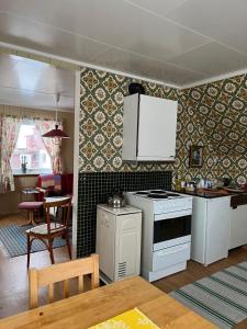 a kitchen with a stove and a dining room at Bogstrand, Dverbergveien 11, 8485 Dverberg in Dverberg