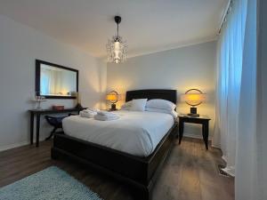 een slaapkamer met een bed met 2 tafels en 2 lampen bij Lulu's Bed & Breakfast in Niagara on the Lake