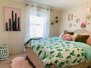 a bedroom with a bed with a green and white comforter at Amazing Views near Grand Canyon Skywalk in Meadview