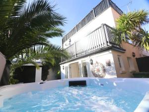 a hot tub in front of a house with palm trees at Arundel Castle River House, The Palms in Arundel
