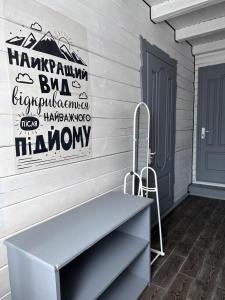 een veranda met een bank en een bord op een huis bij садиба Дерев*яна Хата in Verkhovyna