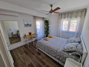 a bedroom with a bed and a table and a mirror at Amazing Terrace Costa da Caparica in Costa da Caparica