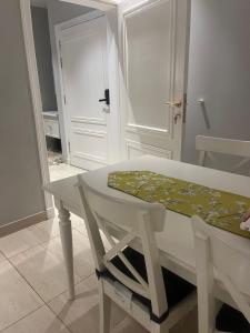 a white table and chair in a room with a door at AlReem Apartment in Al Madinah