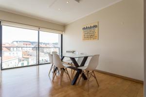 リスボンにあるFLH Alcântara Family Apartmentのダイニングルーム(テーブル、椅子付)、大きな窓が備わります。