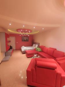 - un salon avec un canapé rouge et un lit dans l'établissement Gogo Apartments, à Ohrid