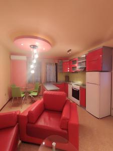 ein Wohnzimmer mit einem roten Sofa und einer Küche in der Unterkunft Gogo Apartments in Ohrid