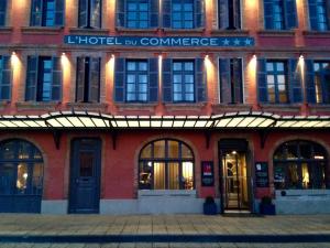 um edifício de tijolos vermelhos com o hotel lb commerce sobre ele em Hôtel du Commerce em Montauban