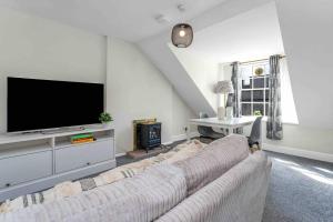 a living room with a couch and a flat screen tv at Stylish 1 Bedroom apartment in Edinburgh