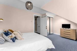 a bedroom with a white bed and a television at Stylish 1 Bedroom apartment in Edinburgh