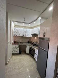 cocina con armarios blancos y nevera en Appartement Relax Saidia, en Saidia 