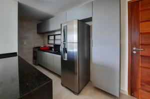 a large stainless steel refrigerator in a kitchen at Wai Wai Cumbuco Vista Lateral Mar 2 Quartos in Cumbuco