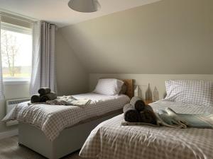 2 łóżka w sypialni z ręcznikami w obiekcie Birchwood View w mieście Aboyne