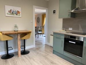 a kitchen with a table and a stove top oven at Birchwood View in Aboyne