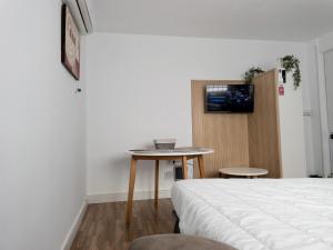 Schlafzimmer mit einem Bett, einem Tisch und einem TV in der Unterkunft Apartamento de Julia in Córdoba