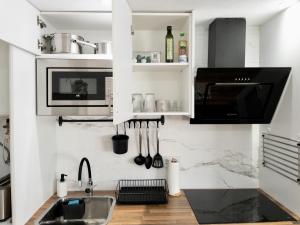 eine Küche mit einer Spüle und einer Mikrowelle in der Unterkunft Apartamento de Julia in Córdoba