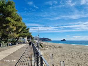 a boardwalk on a beach next to the ocean at La Mansarda di Noi2 in Spotorno