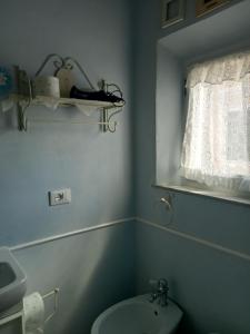 baño con aseo y lavabo y ventana en Casa Alex, en Cascina