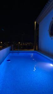 a large blue swimming pool at night at Casa Naranja in Mazarrón