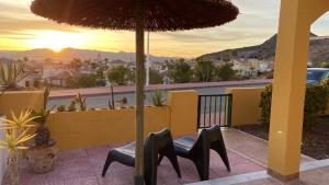 a patio with a table and chairs under an umbrella at Casa Naranja in Mazarrón