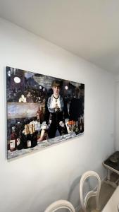 un tableau d'un homme debout derrière un bar sur un mur dans l'établissement 180 home Luxury Redes, à Séville