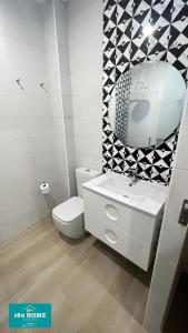 La salle de bains est pourvue de toilettes, d'un lavabo et d'un miroir. dans l'établissement 180 home Luxury Redes, à Séville