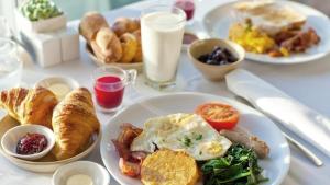 a table topped with plates of breakfast foods and milk at Refresh Boutique Suites - Central Point in Vodice