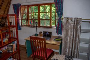 een thuiskantoor met een bureau en een raam bij Creekside in the City in Johannesburg