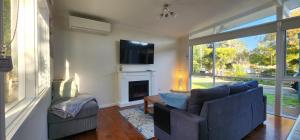 a living room with a blue couch and a fireplace at Beach Cottage. 100m to the beach 9minutes to Hot Springs. Pet Friendly in Capel Sound