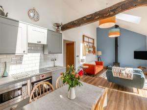 a kitchen and living room with a table and a couch at Kinder in Mellor