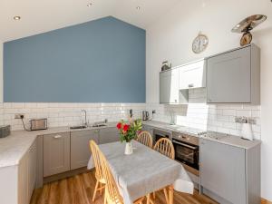 a kitchen with a table with a vase of flowers on it at Kinder in Mellor