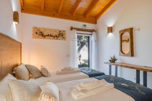 Duas camas num quarto com uma janela em Monte Da Raposeira em Carrascal