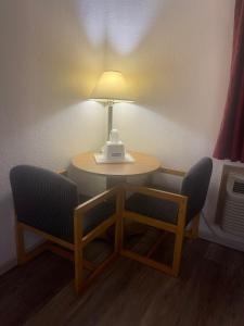 stół z dwoma krzesłami i lampką w obiekcie Travelodge by Wyndham Junction City w mieście Junction City