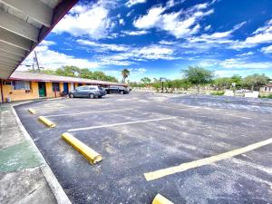a parking lot with a car parked in front of a building at Tropic Motel in Aransas Pass