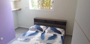 um quarto com uma cama com almofadas azuis e brancas em VILLA JAGUAR em Le Gosier