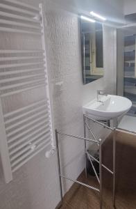 uma casa de banho branca com um lavatório e um espelho em Matera Like Home - rooms - Via del Corso em Matera